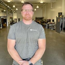 Willy Doerr standing in the landscape shop in a grey tshirt