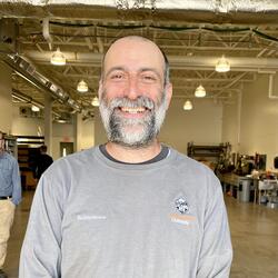 Todd with a smile, beard and grey long sleeve shirt.