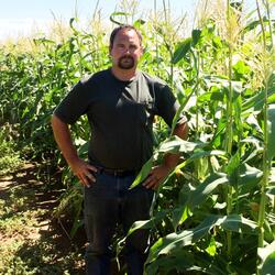 A mechanic standing majestically in a corn field